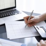 woman-accountant-using-calculator-laptop-computer-while-counting-taxes-client-business-audit-concepts