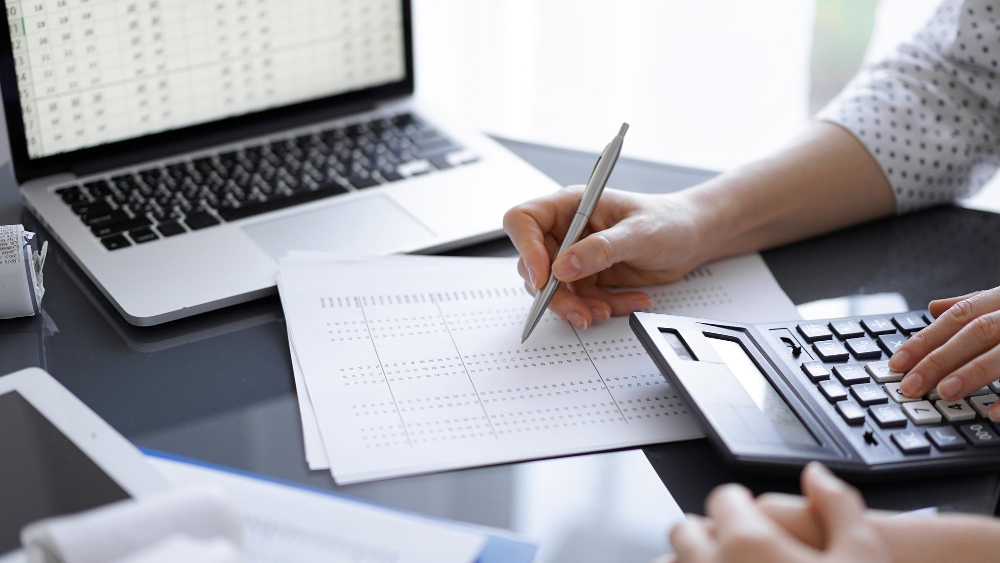 woman-accountant-using-calculator-laptop-computer-while-counting-taxes-client-business-audit-concepts